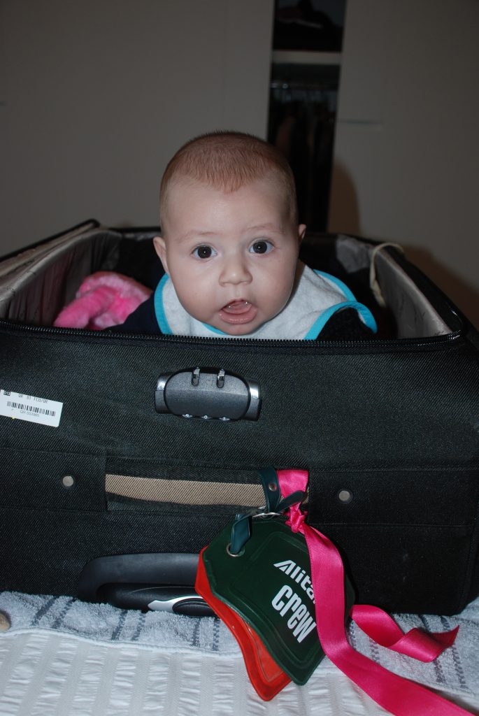 foto di un neonato che si nasconde in una valigia