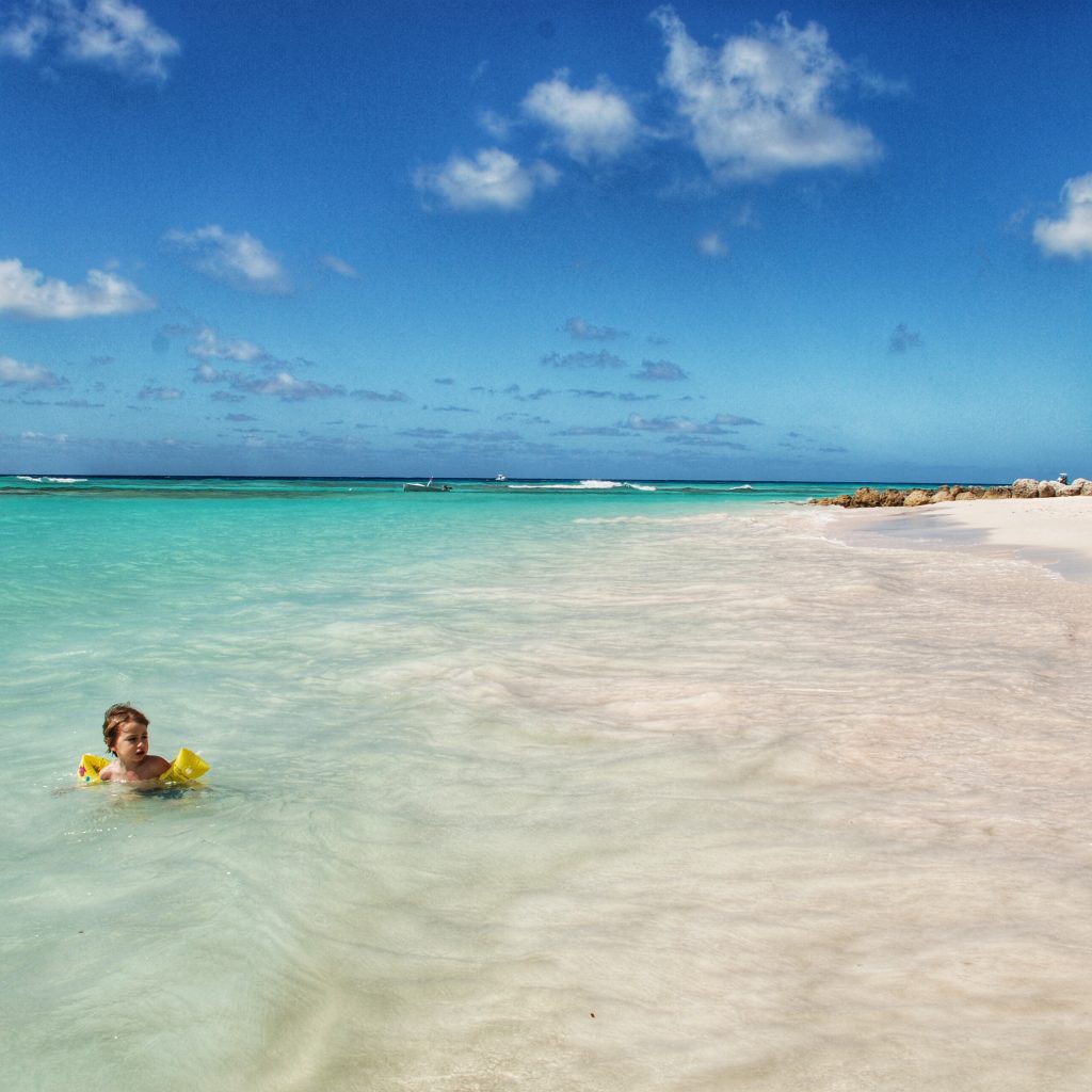 bambino che gioca nell'acqua cristallina di Barbados