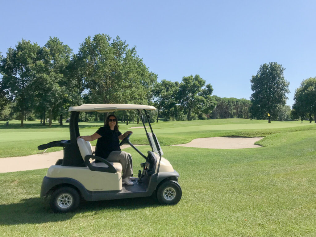 foto di una donna su una golf car al Golf Club Lignano Sabbiadoro